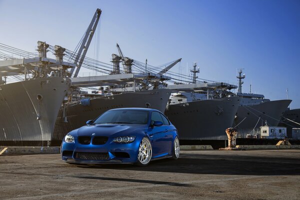 Une BMW bleue sur le quai devant les boîtes