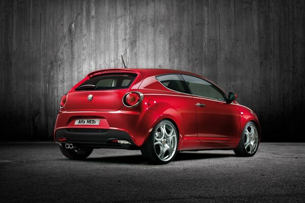 Красный автомобиль Alfa Romeo MiTo на сером фоне