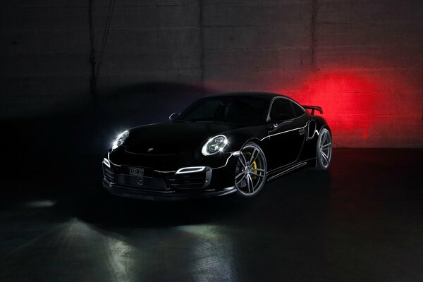 Black Porsche 911 with lights on