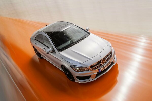 Ein graues Business-Class-Auto rast über den orangefarbenen Streifen