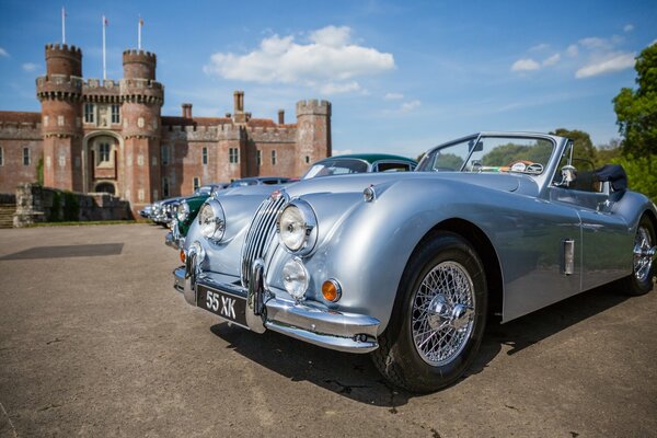 Un coche retro se encuentra cerca de un castillo en Inglaterra