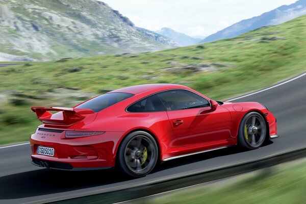 Une Porsche 911 gt3 rouge qui roule sur la route