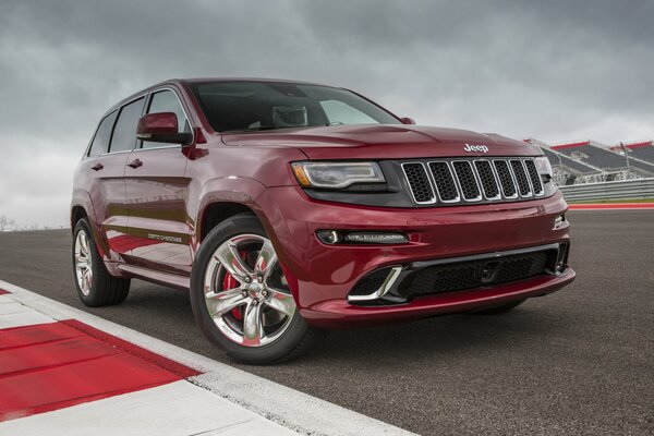 Ein rubinfarbener Grand Cherokee Jeep, der auf einer Rennstrecke steht