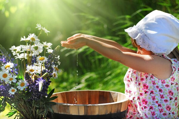 La ragazza versa l acqua in una bacinella per i fiori