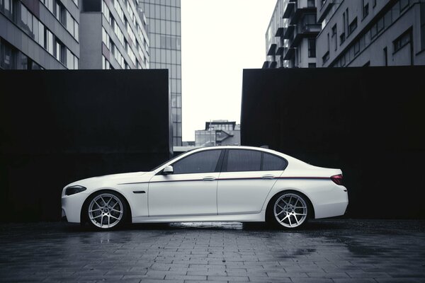 Coche BMW blanco en el fondo de los edificios