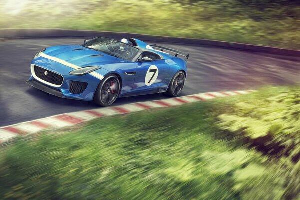 Blauer Jaguar auf einer Rennstrecke in einer Kurve