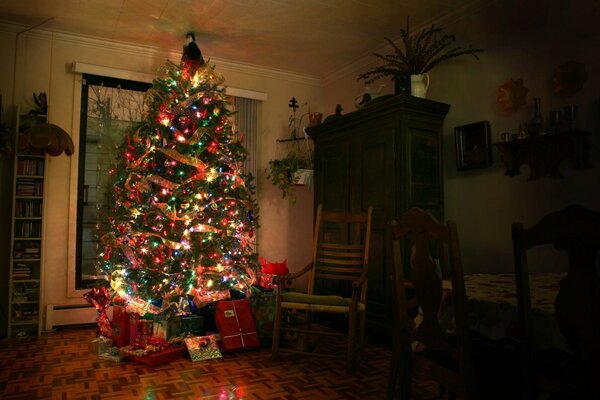 Grande albero di Natale con regali in camera