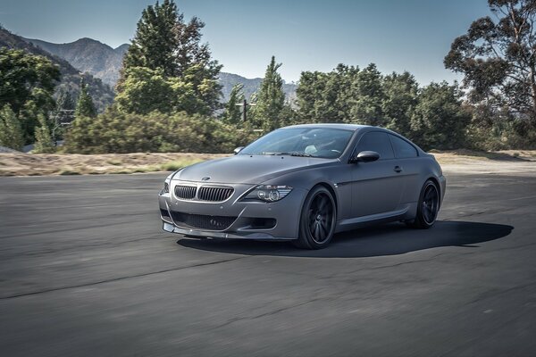 Grey matte bmw on the background of mountains
