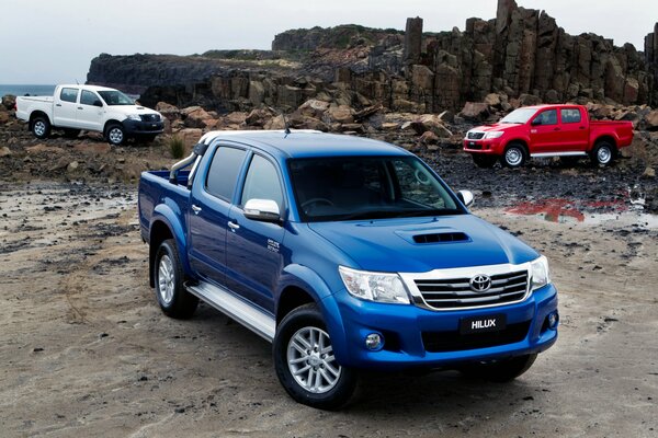 Pickups are parked in the area next to low mountains