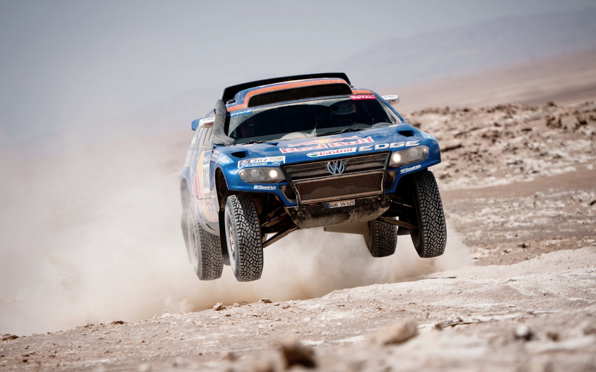 volkswagen tuareg azul dakar rally en el aire volando polvo desierto toro rojo