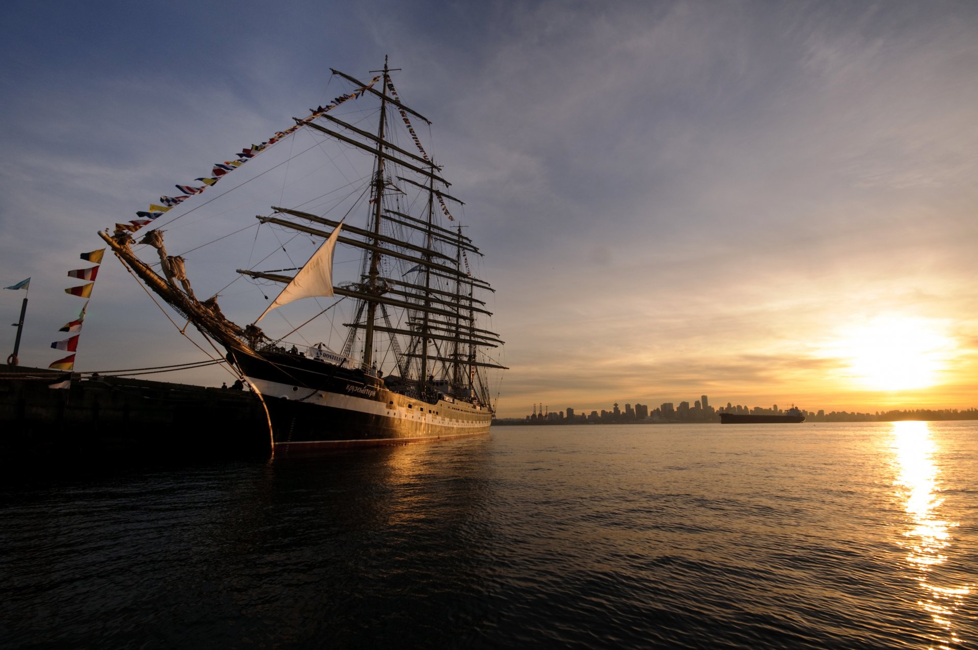 cruisenstern barque voilier navire coucher de soleil quai nez mâts ville