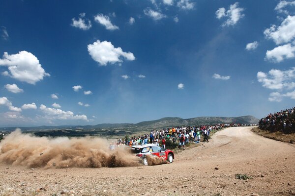 Spectators at the rally watch the Citroen on the turn