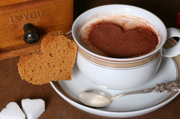 Caffè con cuore su piattino bianco