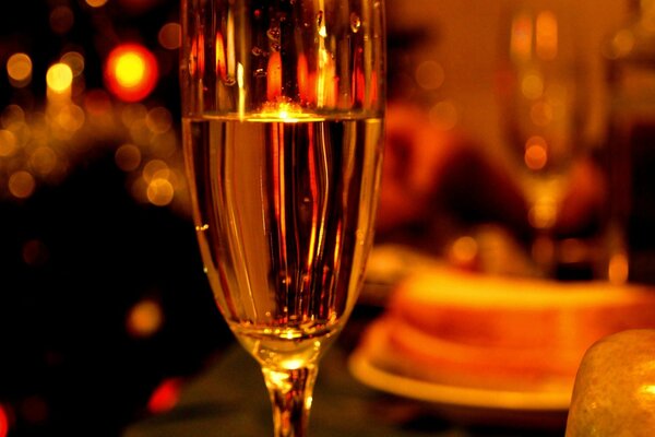 A glass of champagne on the festive table in the evening light