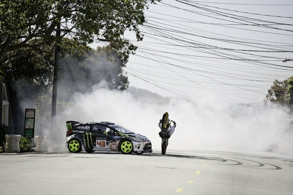 The car drifts around the motorcycle