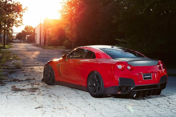 Red Nissan on asphalt with cracks