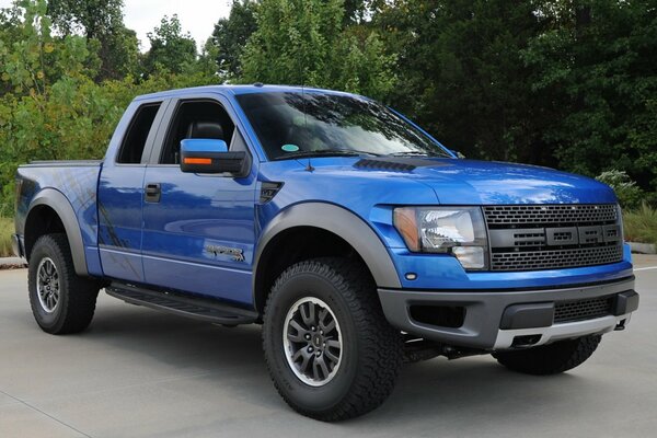 Pickup Ford Raptor auf dem Hintergrund der Bäume