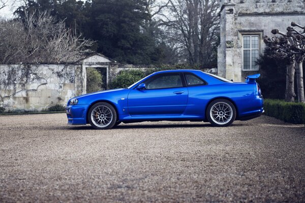 Nissan skyline blu vicino alla vecchia casa