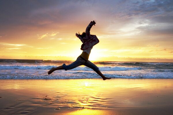 Foto di salto sulla spiaggia al tramonto