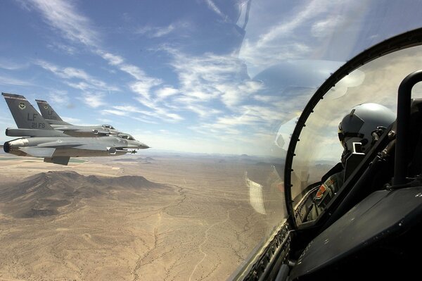 The flight of a fighter jet against the background of a desert landscape