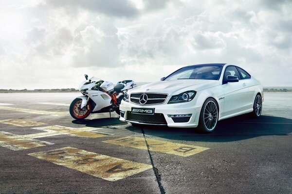 White car and motorcycle on the sky background