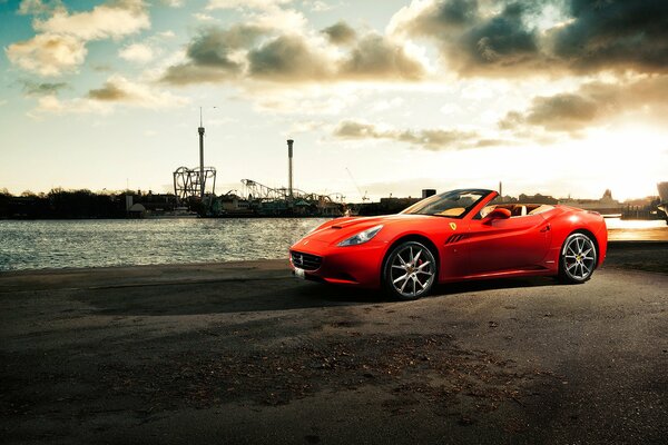 Une voiture Ferrari California sur une jetée au bord de la rivière