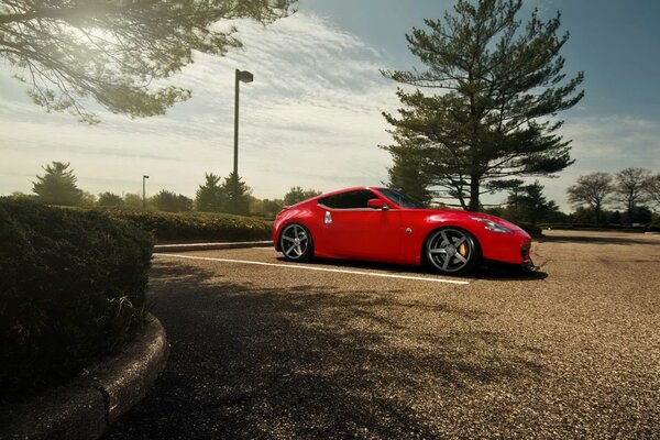 Nissan rouge dans le parking près de l arbre