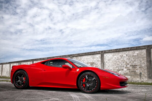 Red Ferari on the background of a brick wall