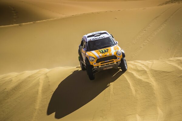 Yellow mini cooper on a sand dune