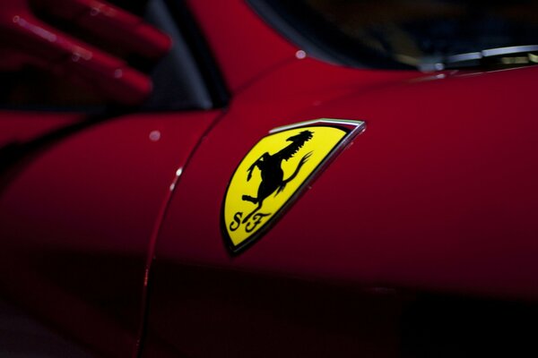 Emblema amarillo de Ferrari en el coche rojo