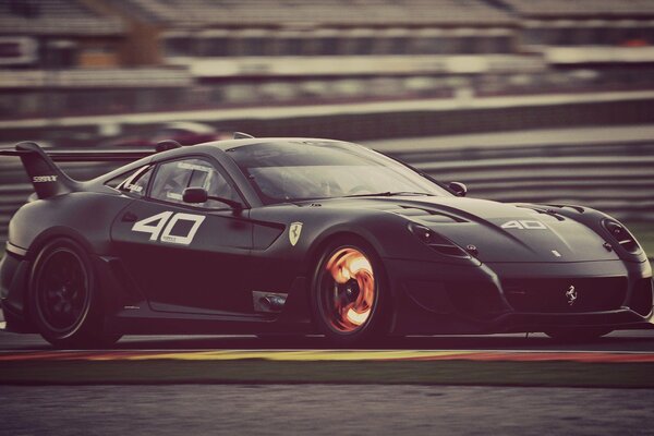 El coche negro va a la velocidad en la pista