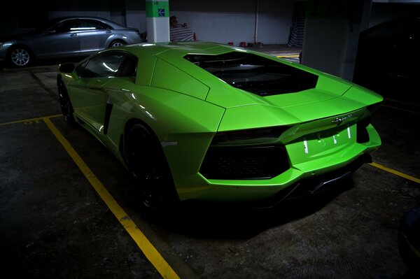 Une voiture verte se trouve sur le parking