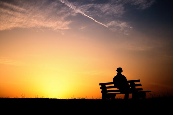 Beautiful sunset with a man on a bench