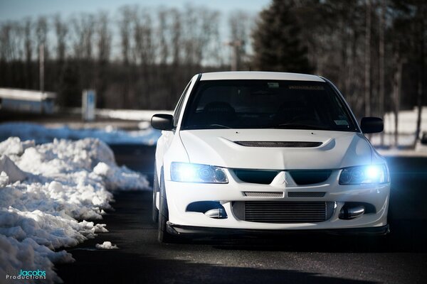 White mitsubishi evolution on the winter road