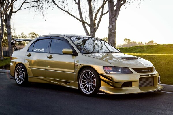 Golden mitsubishi lancer at sunset