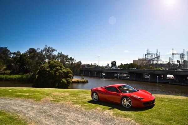 Red Ferrari on the background of the bridge