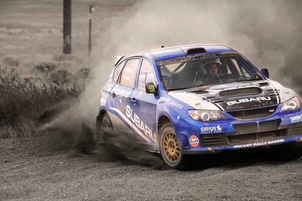 A blue subaru impreza turning at speed with a racer