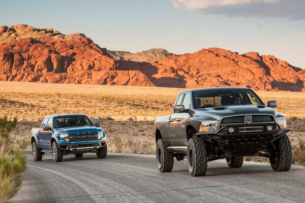 SUVs are driving along the highway among the sands