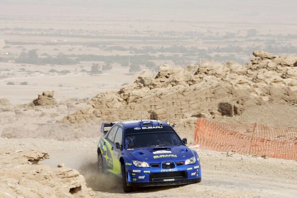 Subaru Impreza im Sand einer grauen Wüste