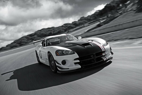 Black and white photo of a Dodge Viper car with a cloudy sky