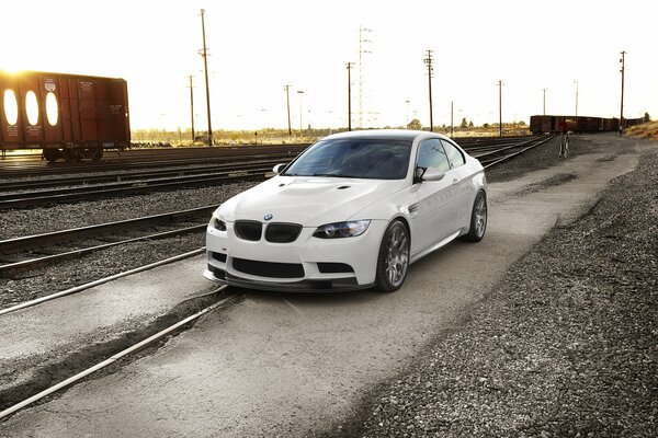 White BMW on the background of the railway