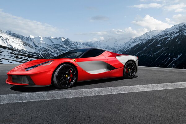 A red car is standing on the road behind it a picturesque Arctic view of snowy mountains