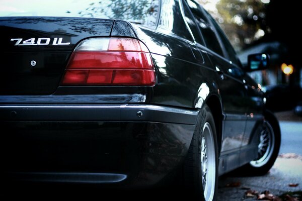 Black BMW seven with red headlights