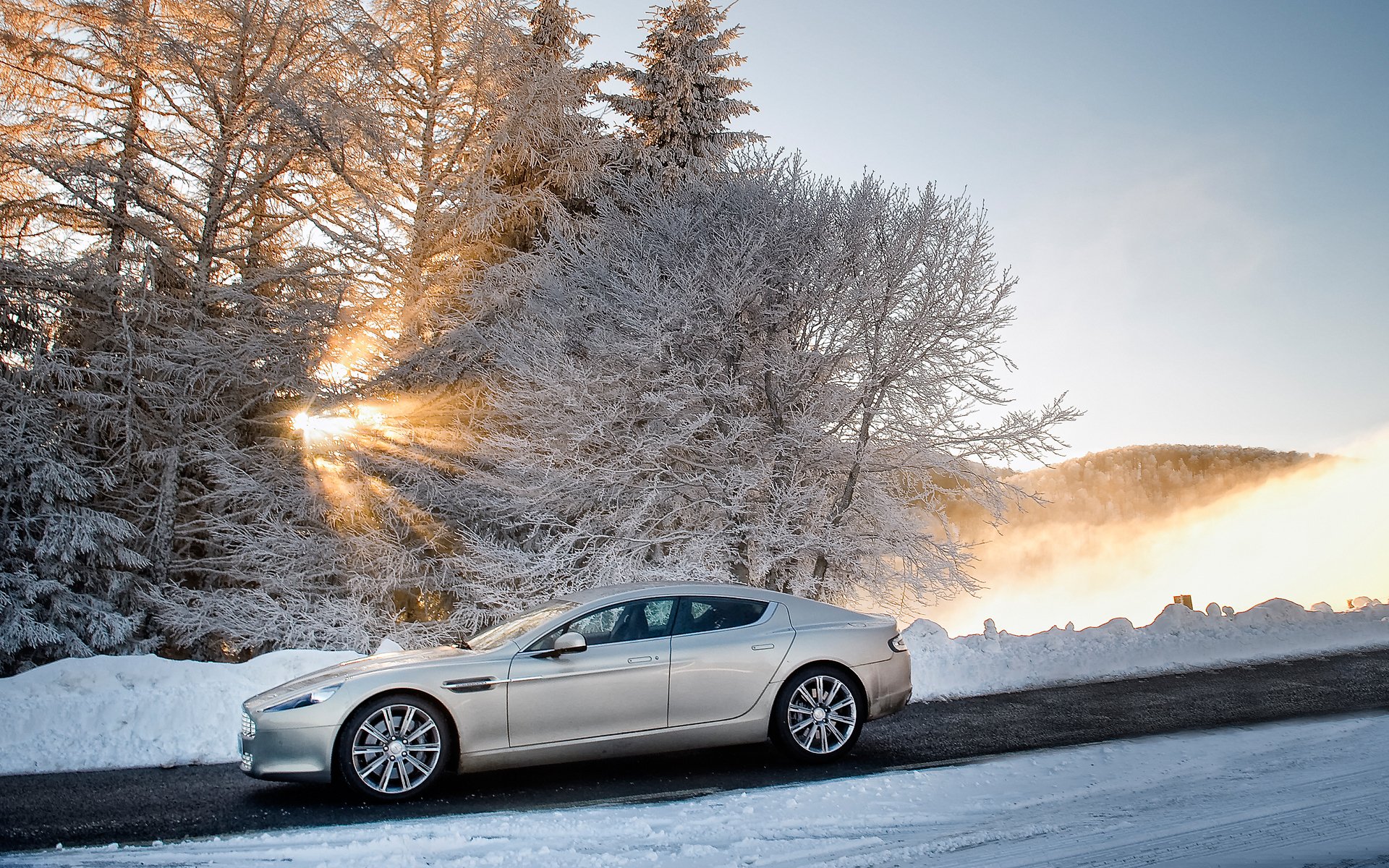 aston martin rapide aston martin rapid sedán vista lateral invierno nieve árboles cielo sol