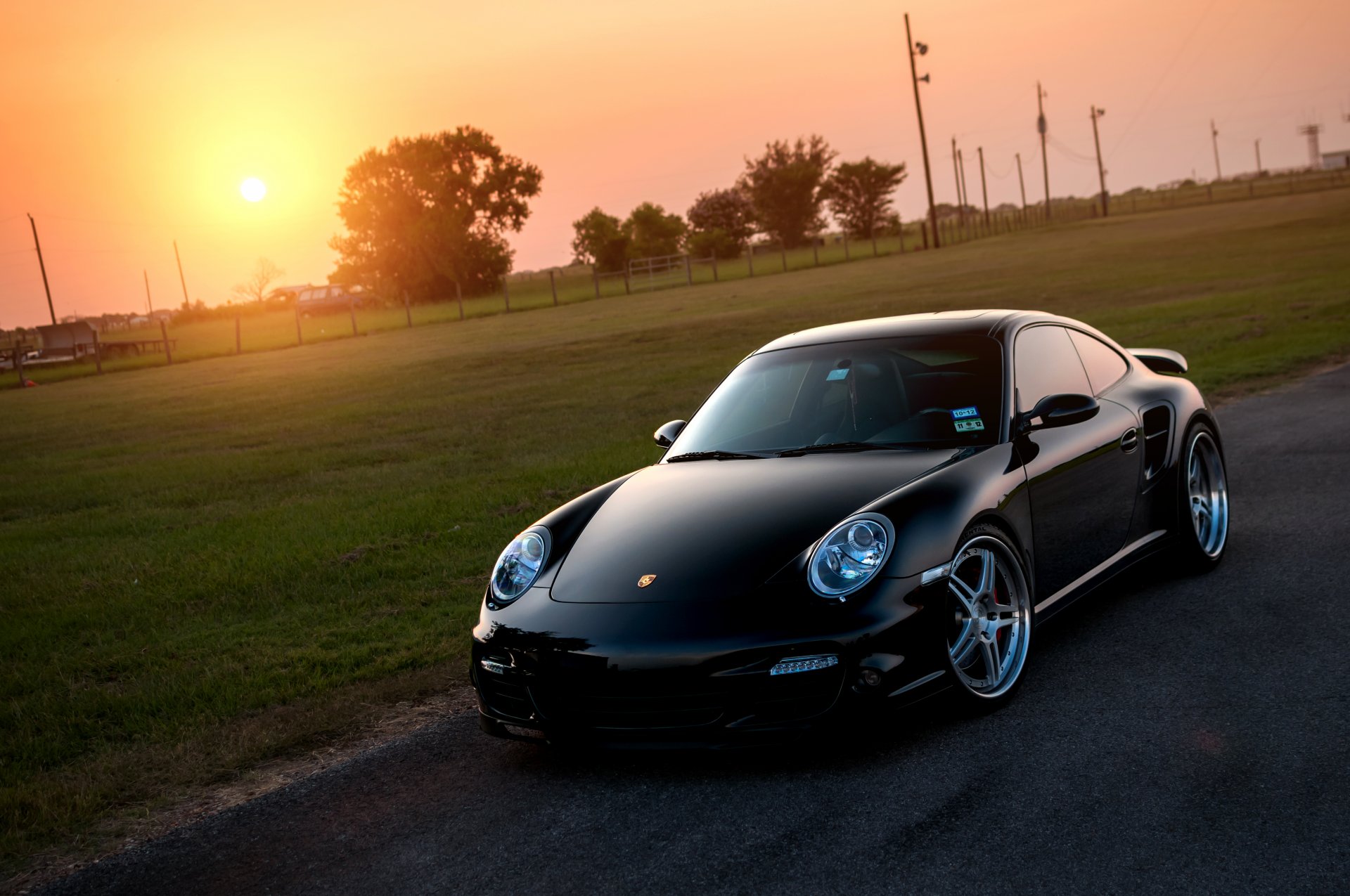 porsche 911 turbo negro frente porsche sol césped resplandor