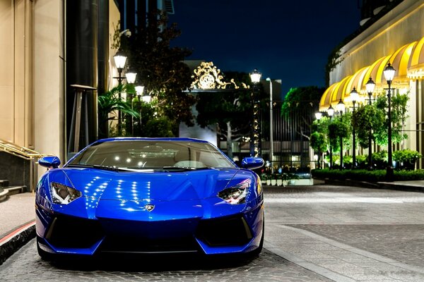 Blauer Lamborghini auf der Nachtstraße vor dem Hintergrund der Laternen