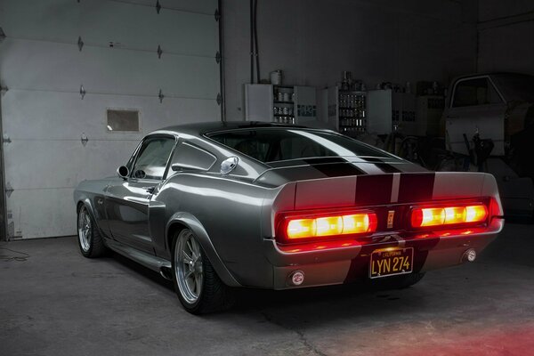 Burning taillights of a black Ford Mustang