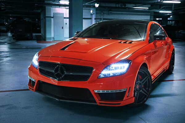 Red car in the parking lot of mercedes-benz cls 63