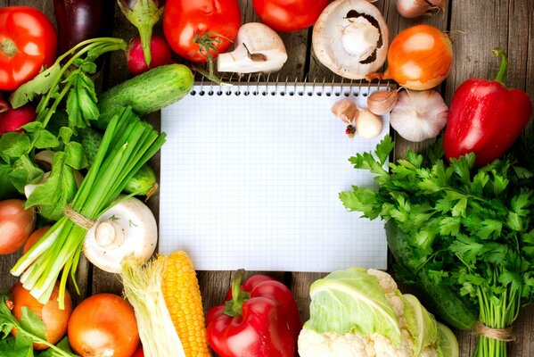 Cuaderno en el fondo de verduras y verduras