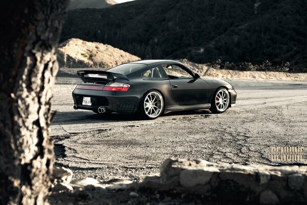 Porsche negro, carrera en la carretera